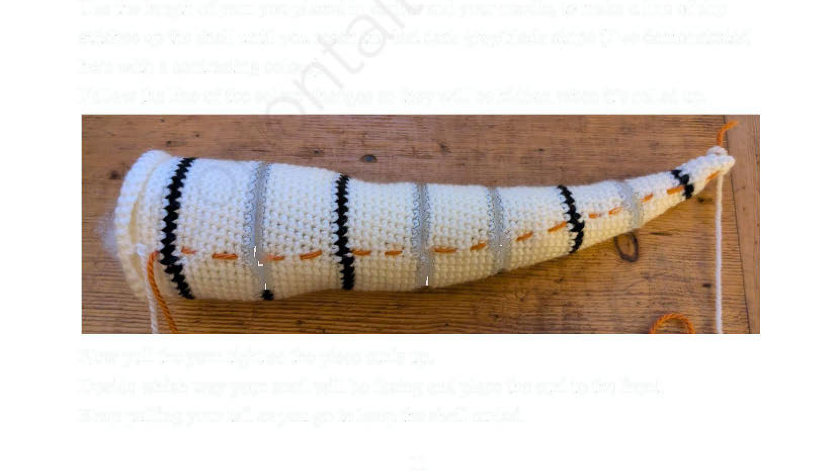 The long, striped crochet shell before being curled