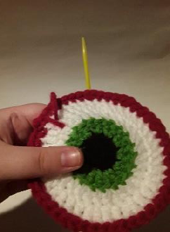 Multiple red veins embroidered onto the white section of the eyeball coaster.