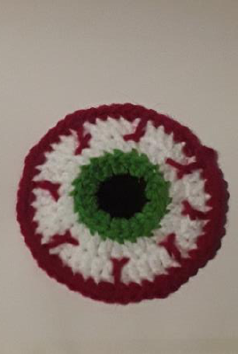 Adding a white embroidered glare to the black pupil of the eyeball coaster.