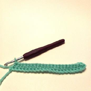 Step 1 of the crochet coaster: working 10 HDC stitches into the starting chain.