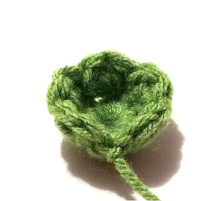Rolling the red crochet piece to form the rose flower