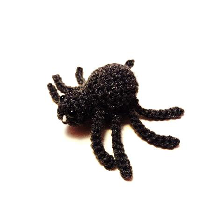 Black crochet spider with eight legs sewn onto its body, ready for attachment
