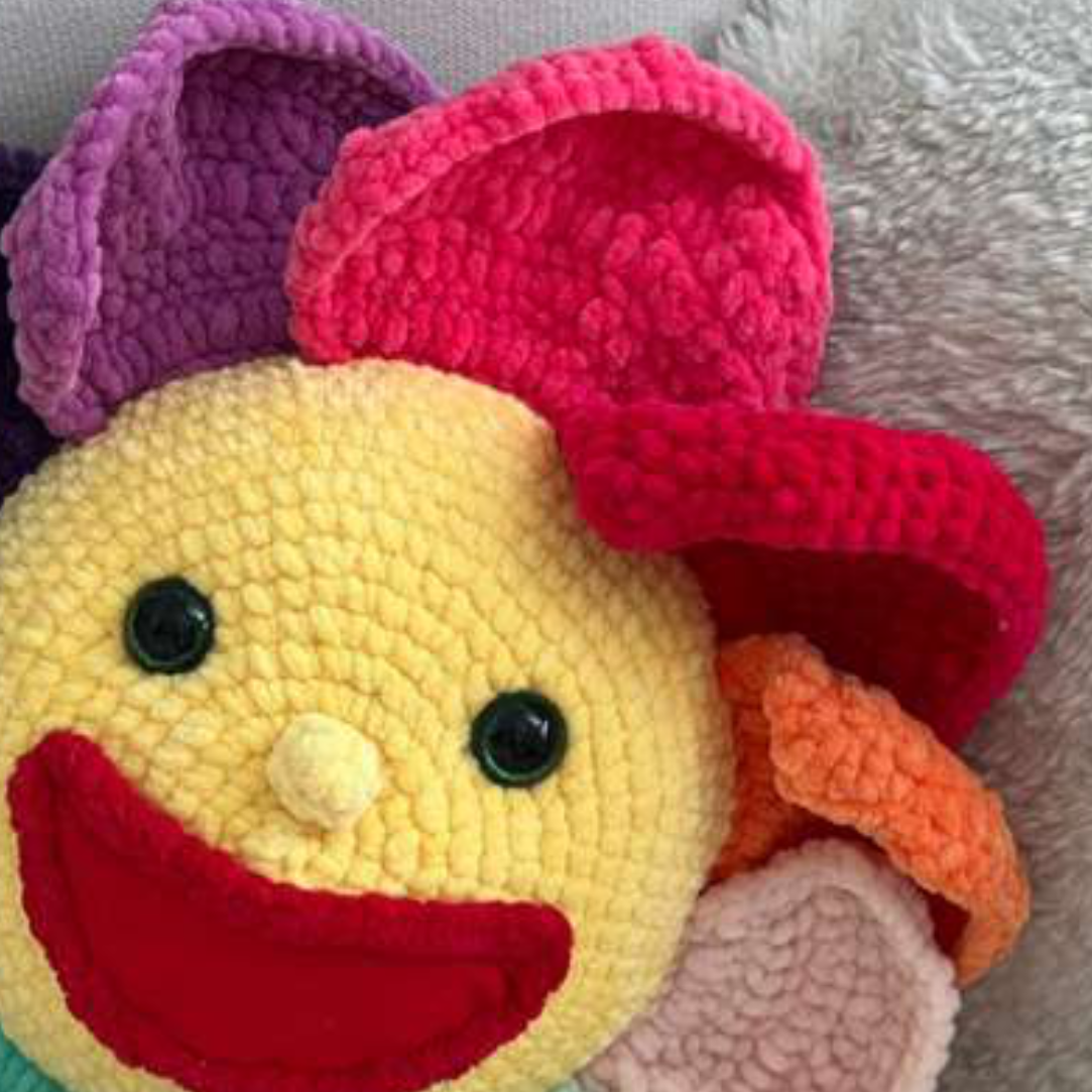 Finished crochet flower pillow with a happy face
