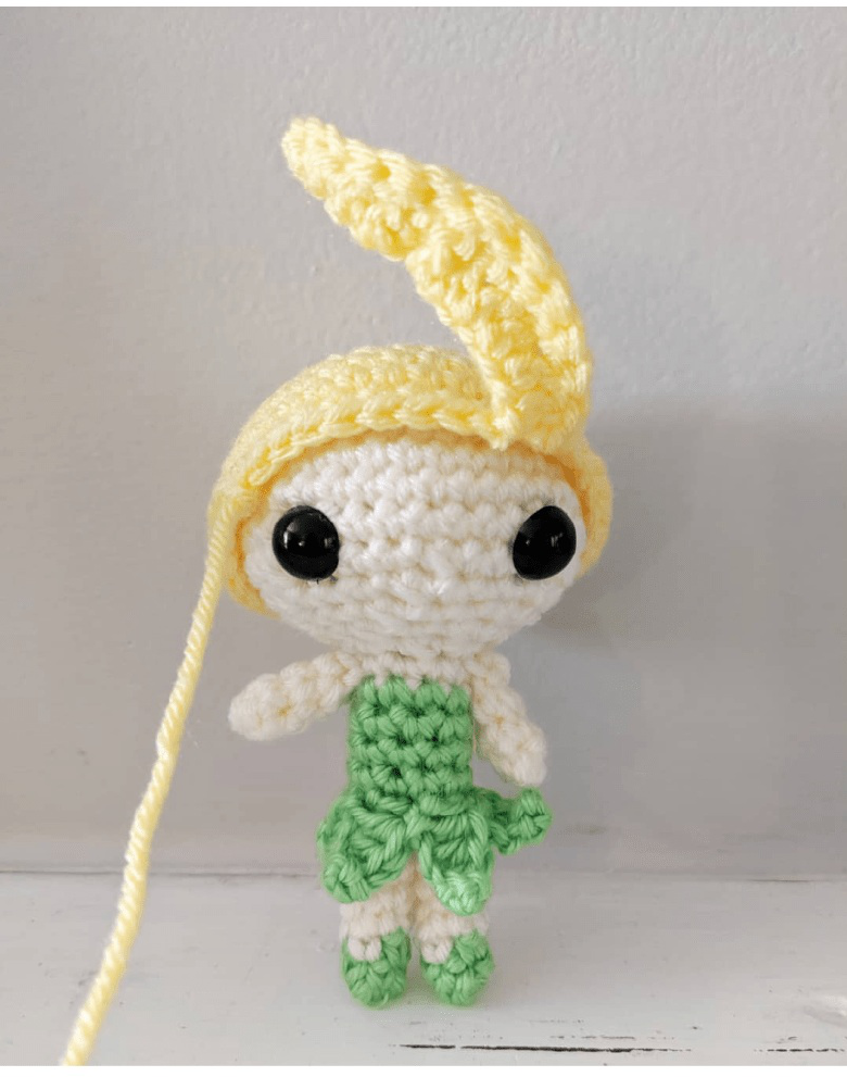 Close-up of the crocheted hair being added to the toy's head