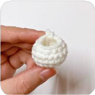 A small, white crocheted cup shape for the base of a lily flower.