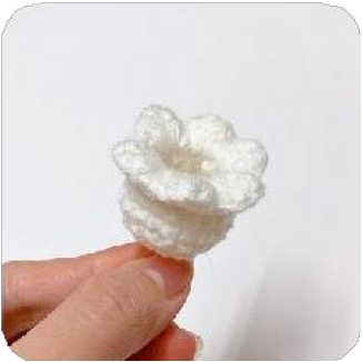 Yellow yarn being wrapped around two fingers to prepare for creating the flower pistil.