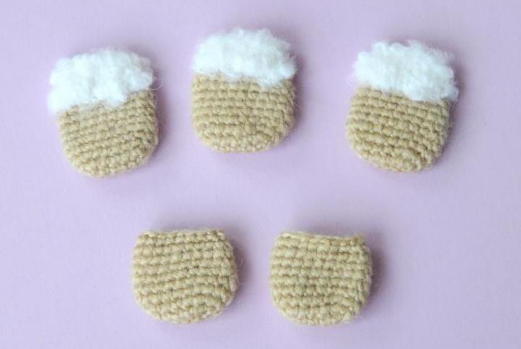 Two crocheted sheep body pieces side by side