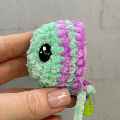 Safety eyes inserted on green crochet fish